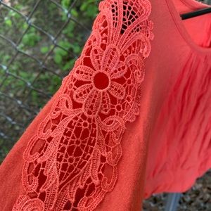 Orange blouse with lace sleeves.